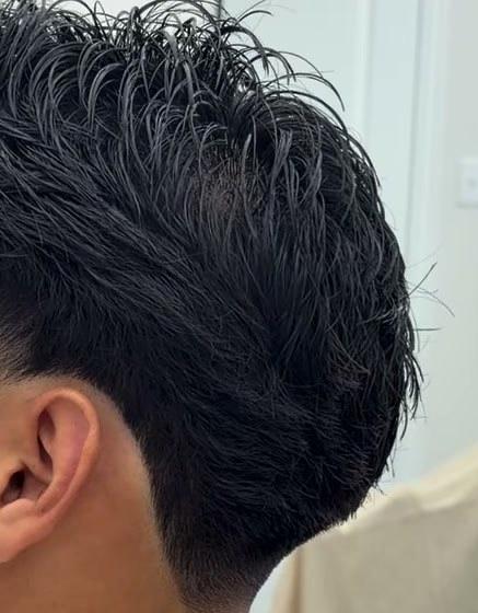 Close side view of a mid taper, the neckline faded clean behind the ear