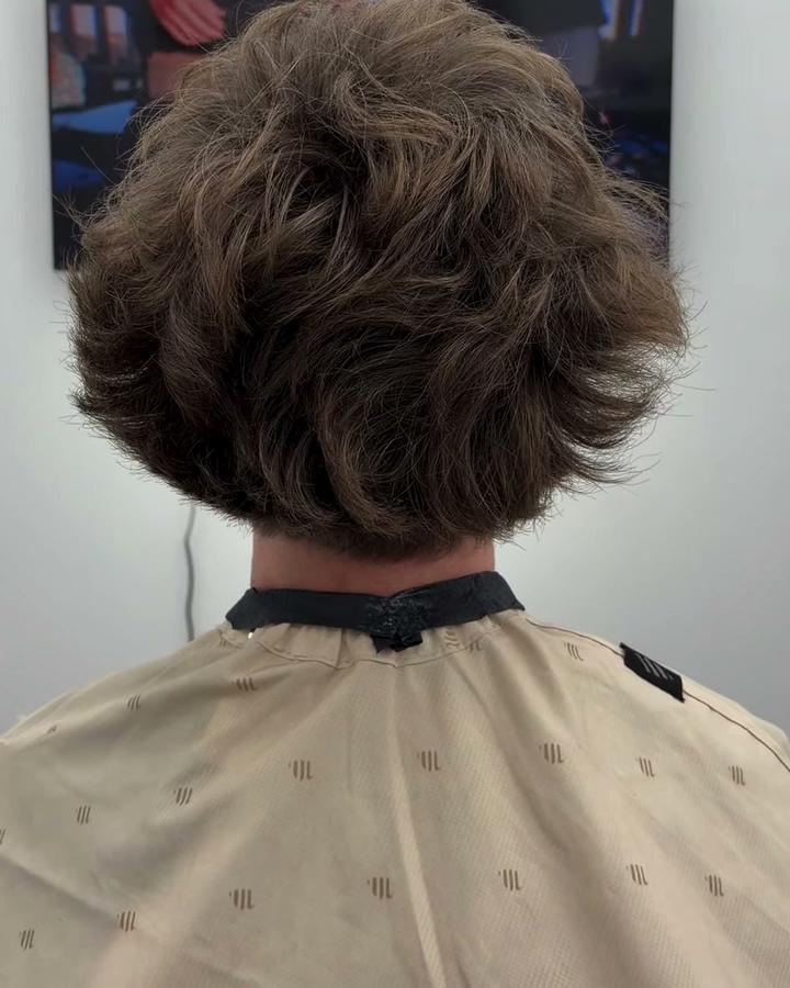 Back view of a taper with long, wavy hair on top